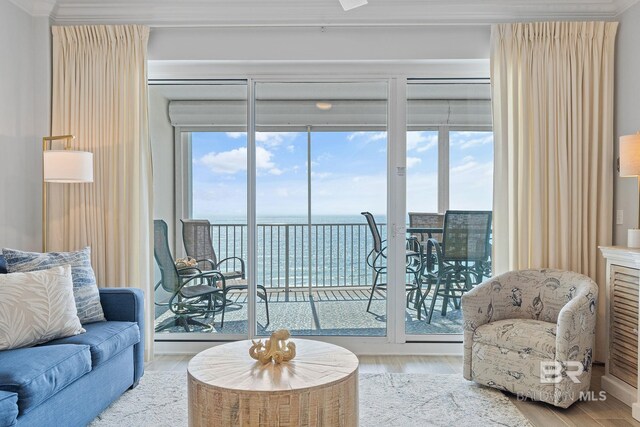 living room with plenty of natural light, a water view, and hardwood / wood-style floors