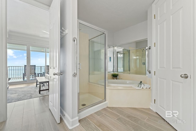 bathroom with hardwood / wood-style floors, separate shower and tub, and crown molding