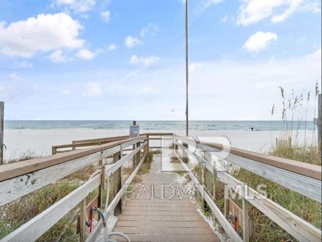 dock area with a water view and a beach view