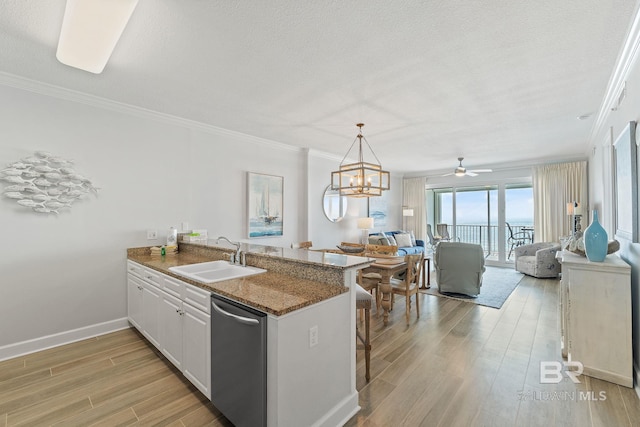 kitchen featuring kitchen peninsula, sink, white cabinets, and stainless steel dishwasher