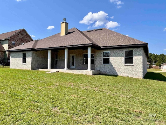 rear view of house featuring a yard