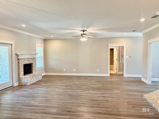 unfurnished living room featuring a fireplace, crown molding, plenty of natural light, and hardwood / wood-style flooring