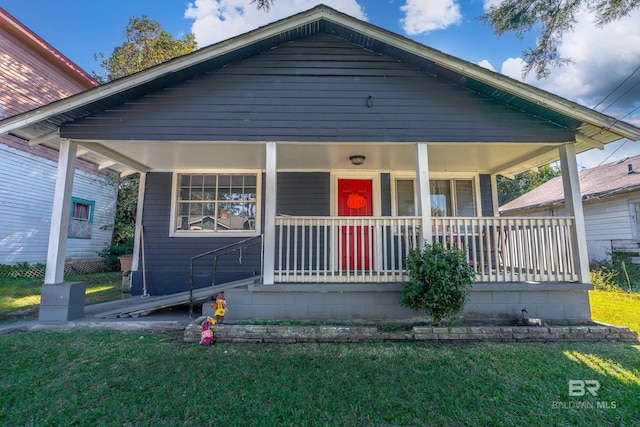 bungalow featuring a porch and a front lawn