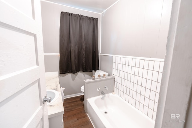 bathroom featuring hardwood / wood-style floors, vanity, a bathtub, and toilet