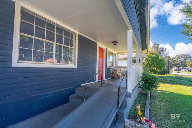 view of property exterior with covered porch and a lawn