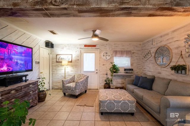 living room with ceiling fan, ornamental molding, and light tile patterned floors