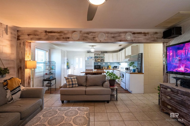 living room featuring light tile patterned floors, ceiling fan, and ornamental molding