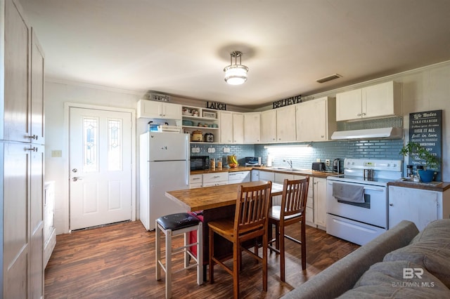 kitchen with white appliances, backsplash, white cabinets, dark hardwood / wood-style floors, and ornamental molding