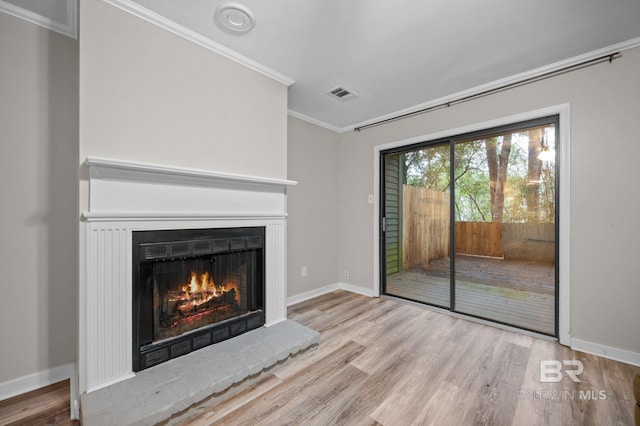 unfurnished living room with light wood-type flooring and ornamental molding