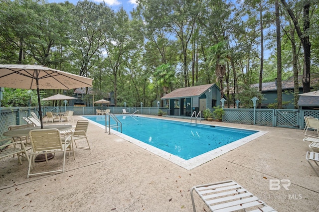 view of pool with an outbuilding and a patio