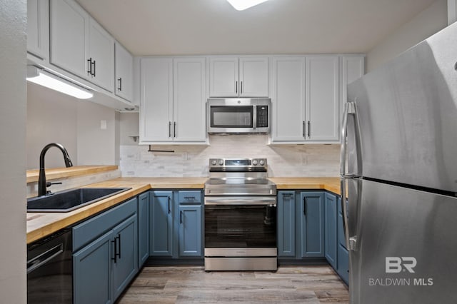 kitchen featuring white cabinetry, sink, appliances with stainless steel finishes, and wooden counters