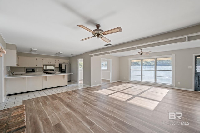 unfurnished living room featuring ceiling fan and light hardwood / wood-style flooring