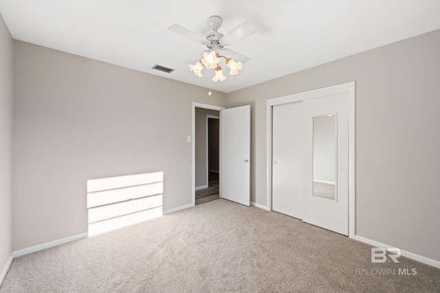 unfurnished bedroom with carpet, a closet, and ceiling fan