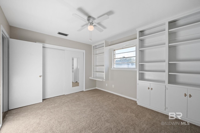 unfurnished bedroom with a closet, light colored carpet, and ceiling fan