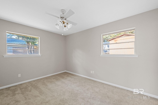 empty room featuring ceiling fan and light colored carpet