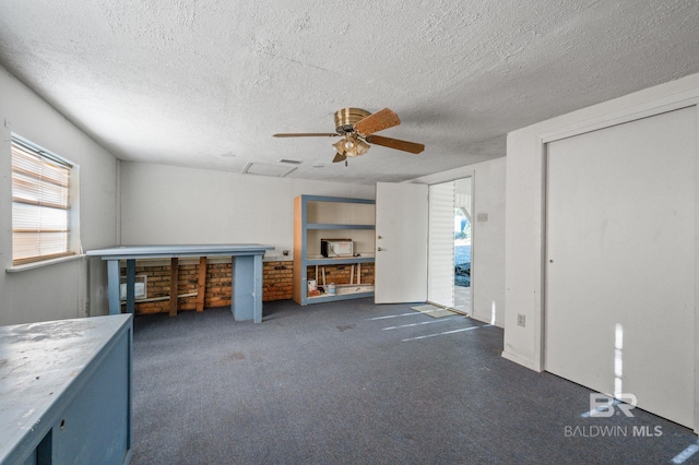 interior space with a textured ceiling and ceiling fan