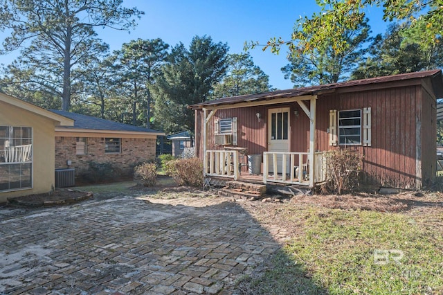 view of front facade with a porch, a patio, and cooling unit