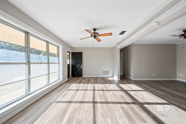 unfurnished living room with ceiling fan and wood-type flooring