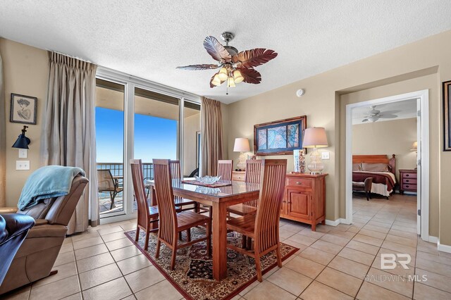 dining space featuring ceiling fan, light tile patterned floors, and a textured ceiling