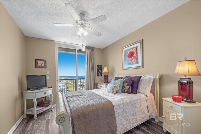 bedroom featuring dark wood-type flooring, access to outside, a textured ceiling, and ceiling fan