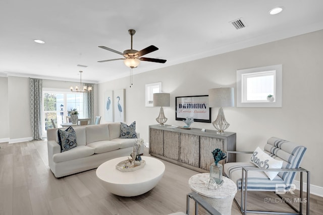 living room with visible vents, baseboards, light wood-type flooring, ornamental molding, and recessed lighting