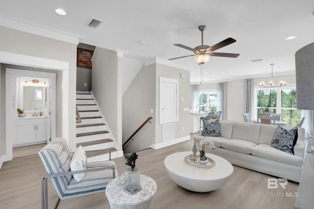 living area with visible vents, light wood finished floors, baseboards, recessed lighting, and crown molding