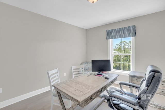 office space with light wood-style floors and baseboards