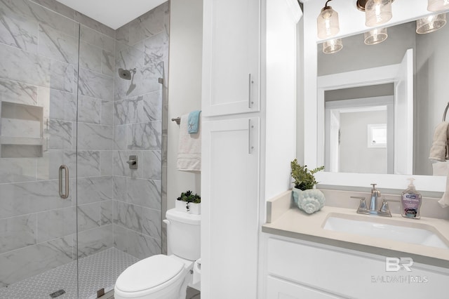 full bathroom featuring toilet, a stall shower, and vanity