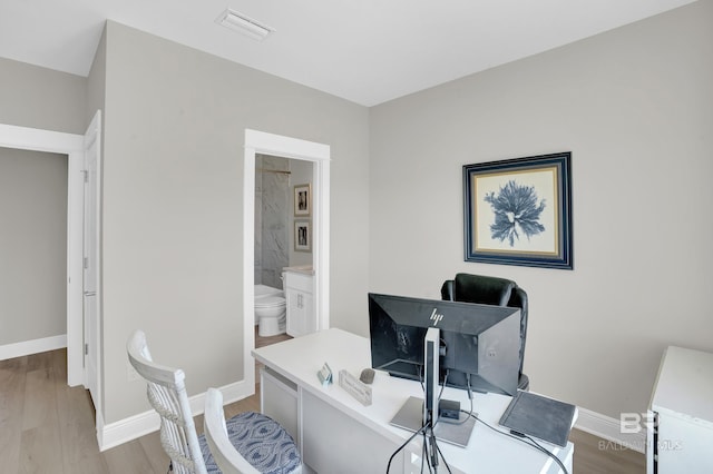 home office with visible vents, baseboards, and light wood-style floors