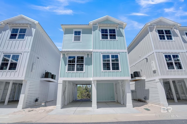 coastal inspired home featuring a carport, stairway, board and batten siding, and driveway