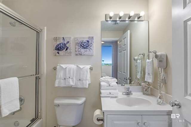 bathroom with toilet, enclosed tub / shower combo, and vanity