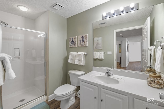 full bathroom featuring toilet, a stall shower, visible vents, and a textured ceiling