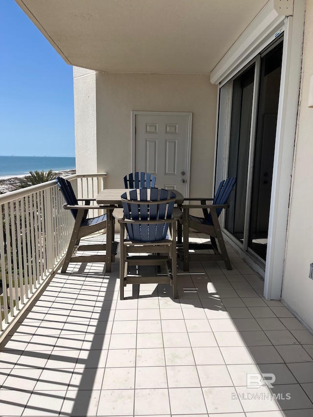 balcony featuring a view of the beach and a water view