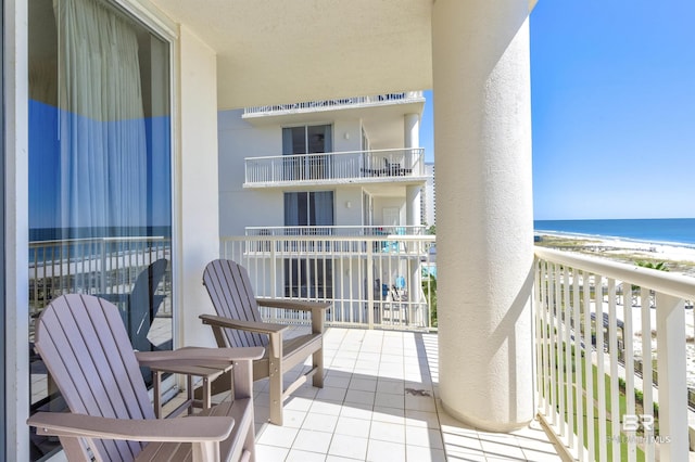 balcony with a water view and a beach view