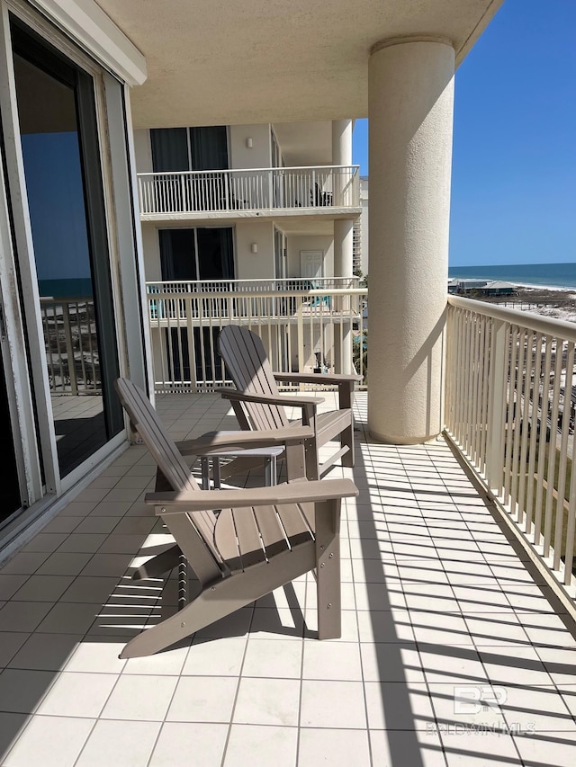 balcony with a beach view and a water view