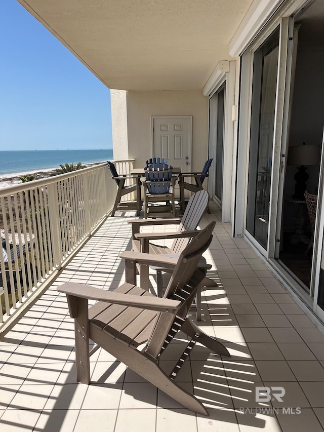 balcony with a water view and a beach view