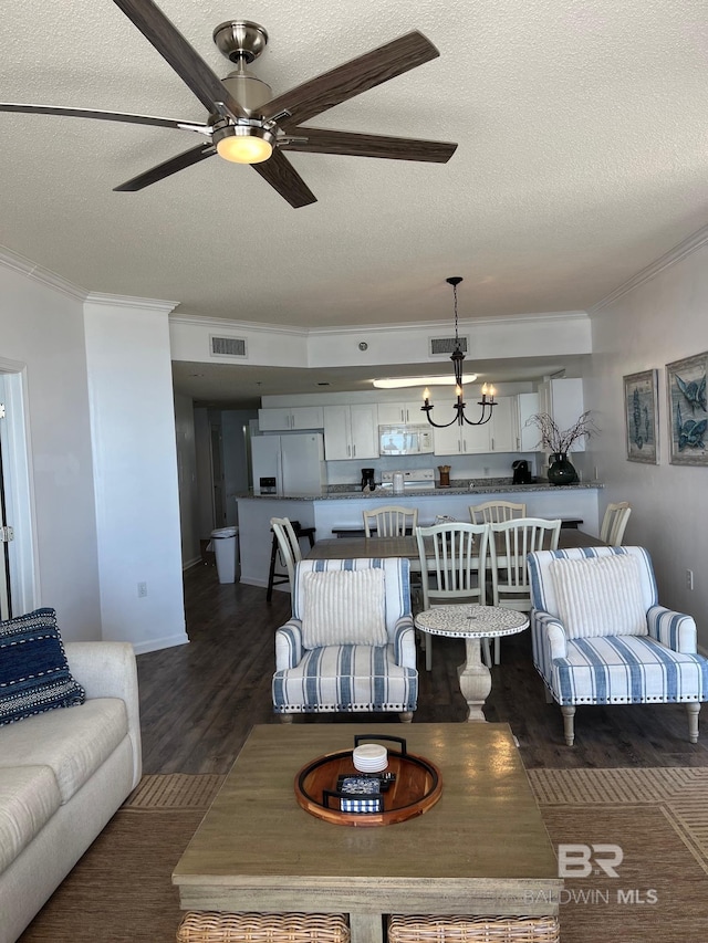 living area featuring a textured ceiling, visible vents, dark wood-style flooring, and ornamental molding