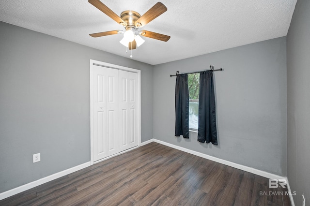 unfurnished bedroom featuring dark wood-type flooring, ceiling fan, a textured ceiling, and a closet