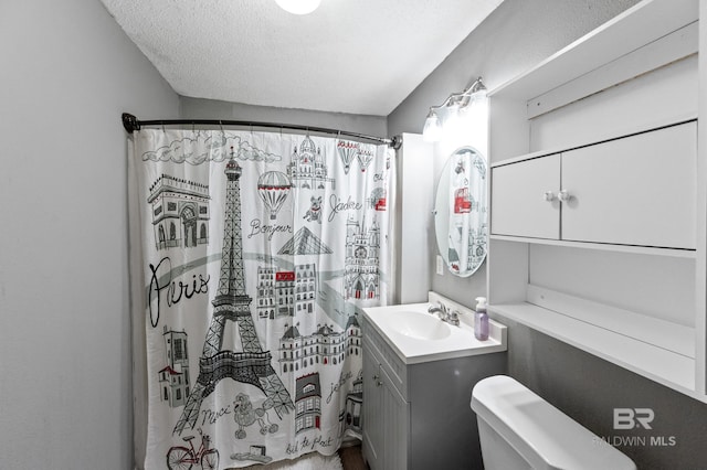 bathroom with a shower with curtain, vanity, toilet, and a textured ceiling