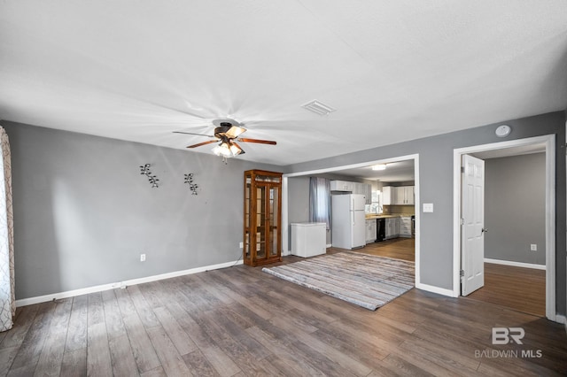 unfurnished living room with dark wood-type flooring and ceiling fan