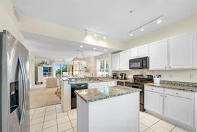 kitchen with white cabinets, track lighting, black appliances, and a center island