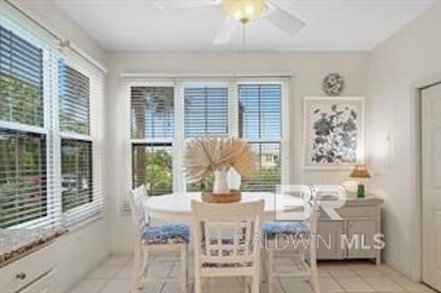 dining room featuring a healthy amount of sunlight, ceiling fan, and light tile floors