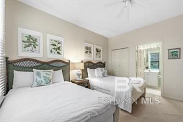 carpeted bedroom with ensuite bath and ceiling fan