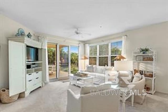 carpeted living room with ceiling fan