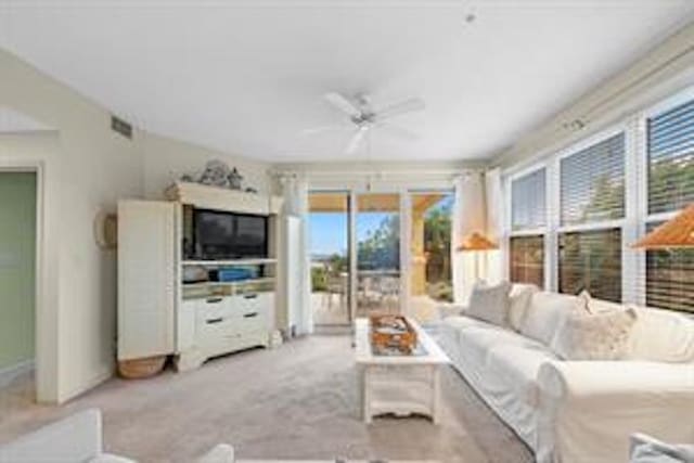 living room featuring ceiling fan, a healthy amount of sunlight, and light colored carpet