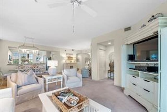 living room with ceiling fan and light colored carpet