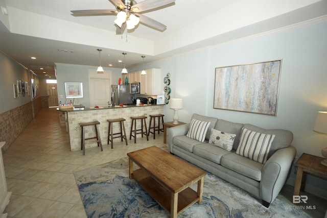 living room with ceiling fan, light tile patterned floors, and crown molding