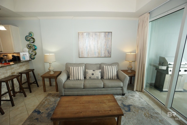 living room with crown molding, light tile patterned floors, and a brick fireplace