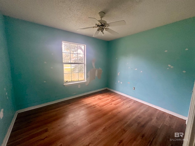 spare room featuring hardwood / wood-style floors and a textured ceiling