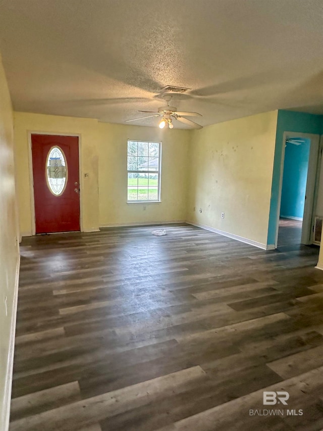 entryway with a textured ceiling, ceiling fan, and dark wood-type flooring